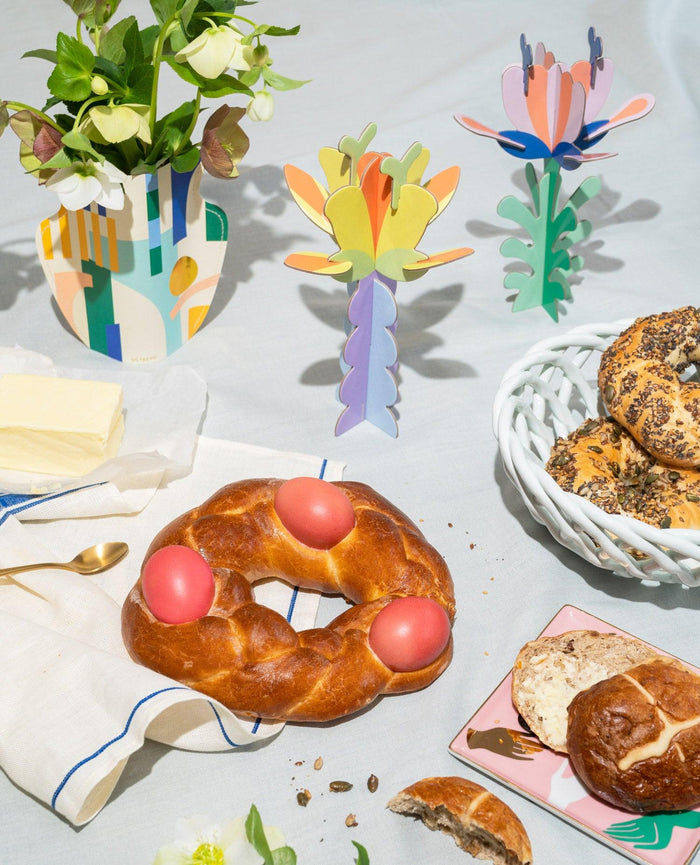 Breakfast table with Funky Bakers pastries and bagels beside colourful OCTAEVO paper flower sculptures.