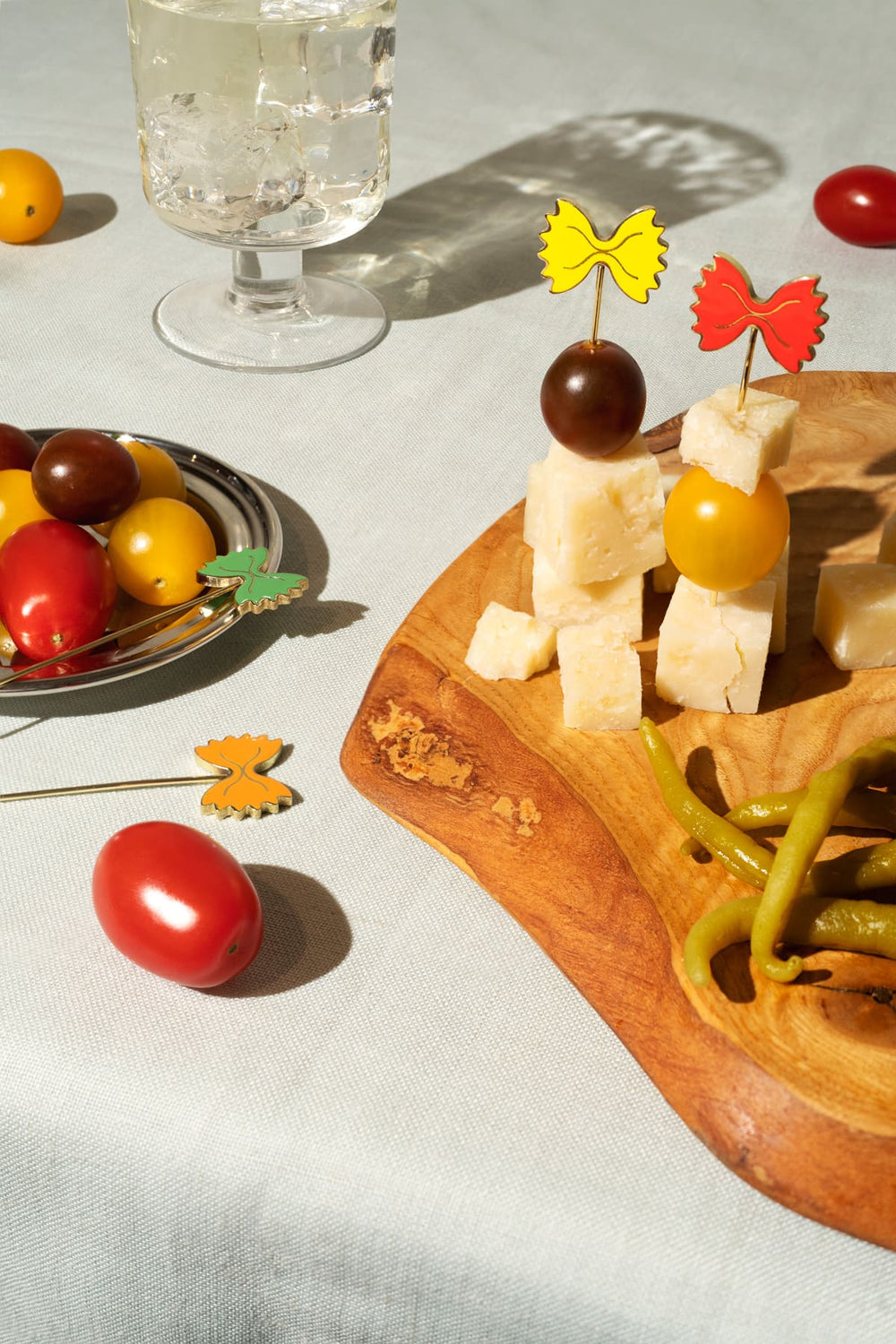 Cheese and tomatoes with OCTAEVO’s Pasta Party Cocktail Picks (Set of 4), styled on a bright tablecloth.