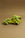 Octaevos Green Grape Candle with stem makes stylish Italian tabletop decor on a plain brown surface.