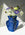 The OCTAEVO Jaime Hayon Paper Vase with abstract faces holds purple, white, and green flowers in sunlight.