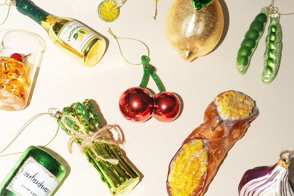 Food- and drink-themed ornaments, including a lemon, cherries, peas, cannoli, drink bottles, glass with ice and a red onion.