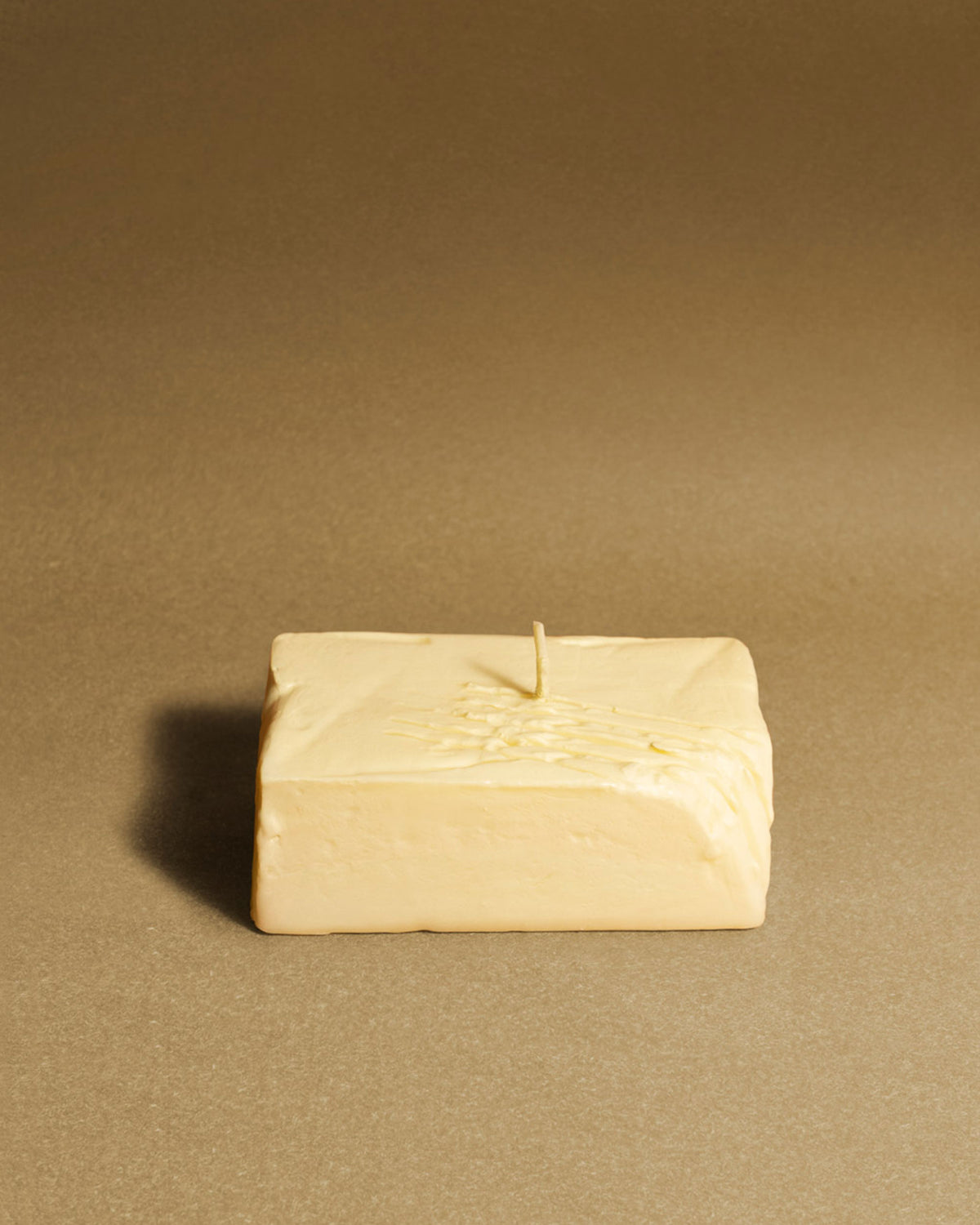 Octaevo's Host With The Most Set: quirky butter and cheese candles beside a block of butter on a brown surface.