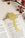 The OCTAEVO Bookmark Magic Mushroom, a gold metal marker, is shown on an open book with red berries nearby.