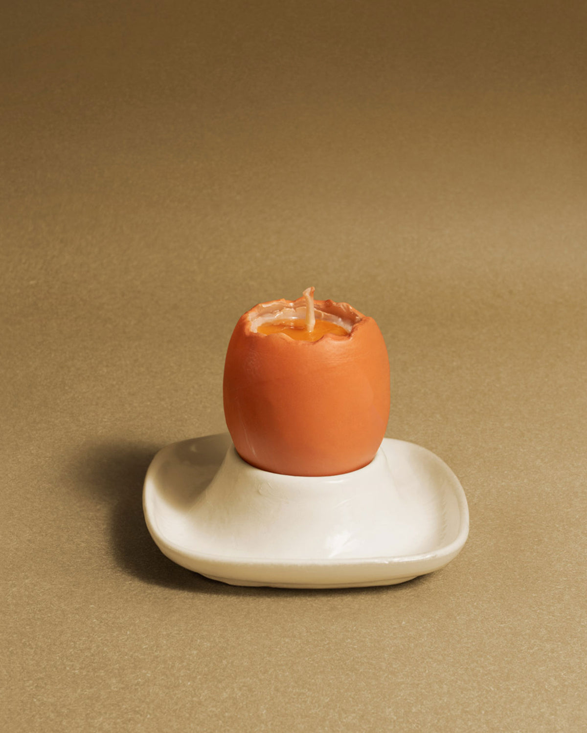 The OCTAEVO Soft-Boiled Egg Candle sits on a white dish, perfect for adding a breakfast-themed touch to your decor.