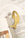 The OCTAEVO Bookmark Sardine, finely cut from brass, rests on the open pages of a book on marble.