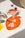 A martini sits on OCTAEVO Fish Splash Coasters (Set of 4) in orange, garnished with grape and fish skewer, beside a lemon.