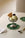 Pistachio ice cream in a metal cup on OCTAEVO Lily Leaf Coasters (Set of 4), with cherry, cookie, and spoon.
