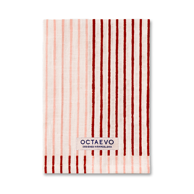 Un paño de cocina rectangular con rayas verticales rosas sobre un fondo blanco, con el nombre de la marca 'OCTAEVO' impreso cerca de la parte inferior.