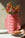 A hand holds the Aurea Paper Vase by OCTAEVO, filled with orange and pink flowers, casting patterned shadows.
