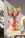 The OCTAEVO Hamsa Paper Vase in pink with colorful handprints holds snapdragons, set on books atop a yellow chair.