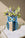 The Octaevo Night Owl Paper Vase holds assorted purple, white, and green flowers on a marble table.