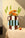 Octaevo Patio Paper Vase with orange and white flowers sits on a beige table beside a single peach.