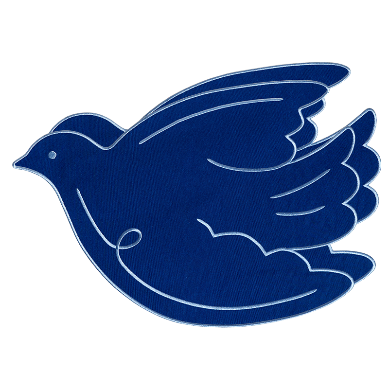A blue ‘Paloma’ placemat by OCTAEVO, featuring a flying dove.