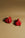 OCTAEVO Strawberry Candles, Set of 2, feature hand-poured red strawberry shapes with green bases on a tan surface.