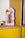 Octaevo Air Paper Sculpture in pink and gold adds artistic decor on a yellow shelf; books are partly visible at right.