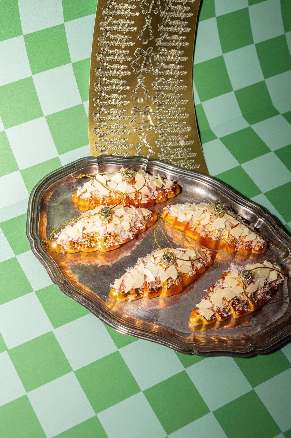 OCTAEVO Almond Croissant Ornament displayed on a silver tray a green checkered cloth.