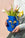 Person holds the Apolino Mini Paper Vase by OCTAEVO, filled with tulips, against a pale background.