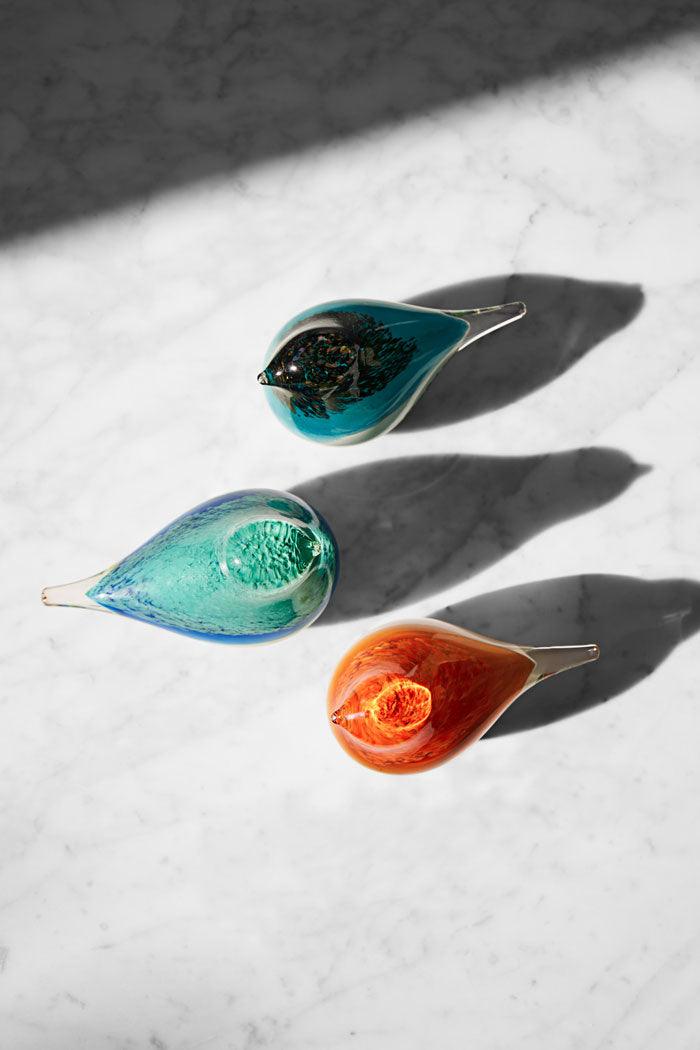 A trio of coloful OCTAEVO Atlas Glass Bird trio brighten any sunlit marble display.