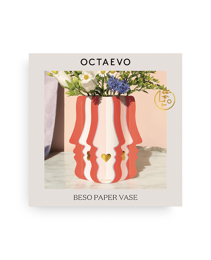Die Beso Mini-Papiervase von Octaevo zeigt rot-cremefarbene Gesichtsprofile mit Herzen, dazu bunte Blumen.