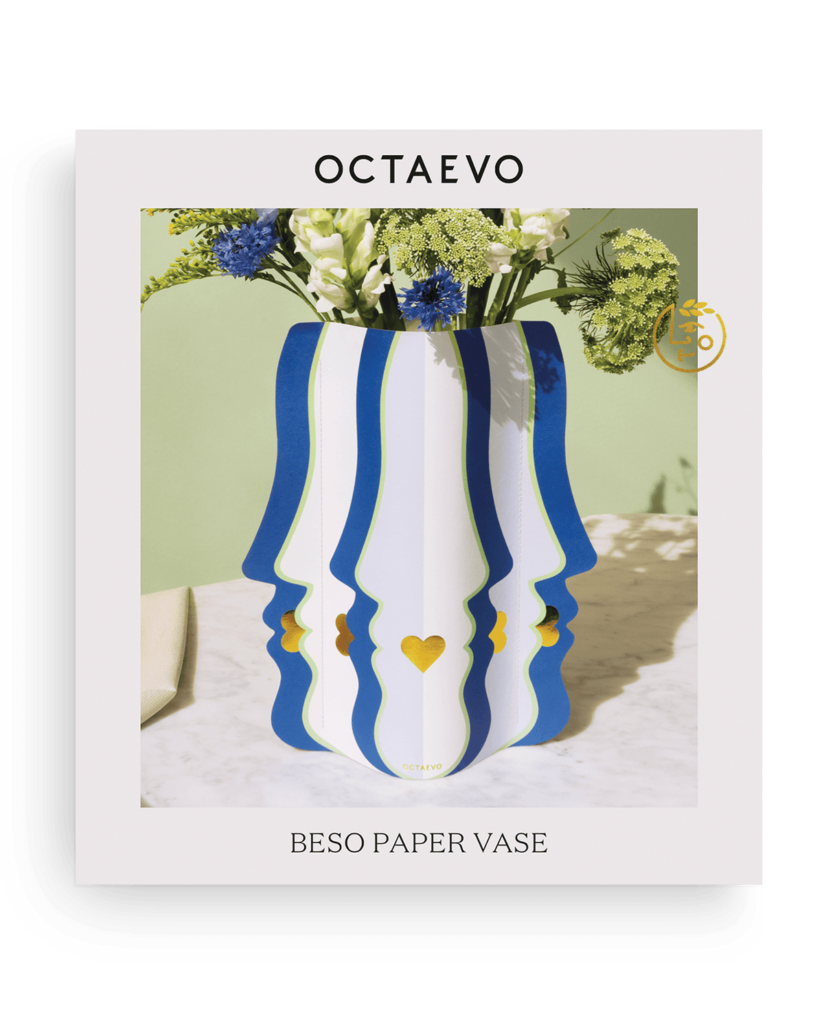 Die Octaevo Beso Papiervase in Weiß und Blau mit Gesichtsprofilen, wasserabweisend, hält Blumen auf Marmorflächen.