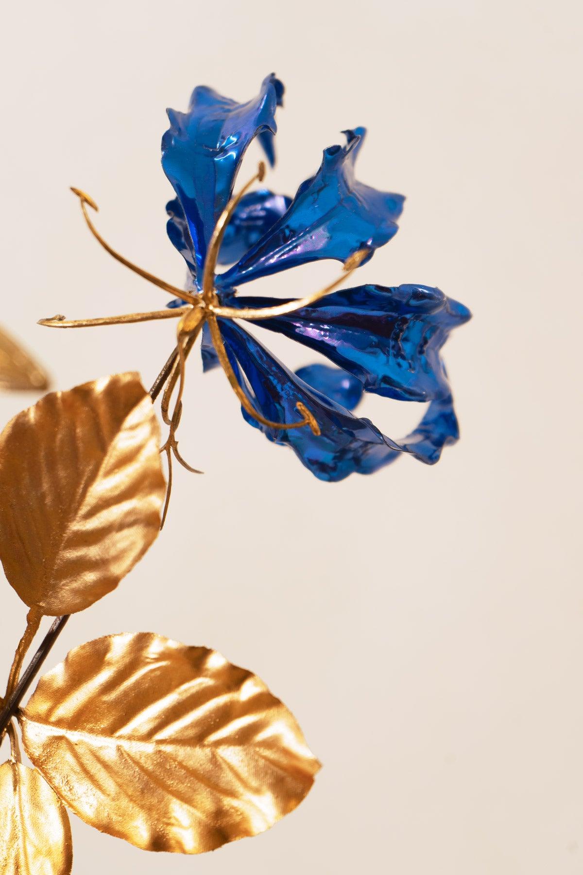 A close-up of Octaevo’s Blue Gold Leaf Bouquet, showcasing blue metallic petals with gold leaves and stem.