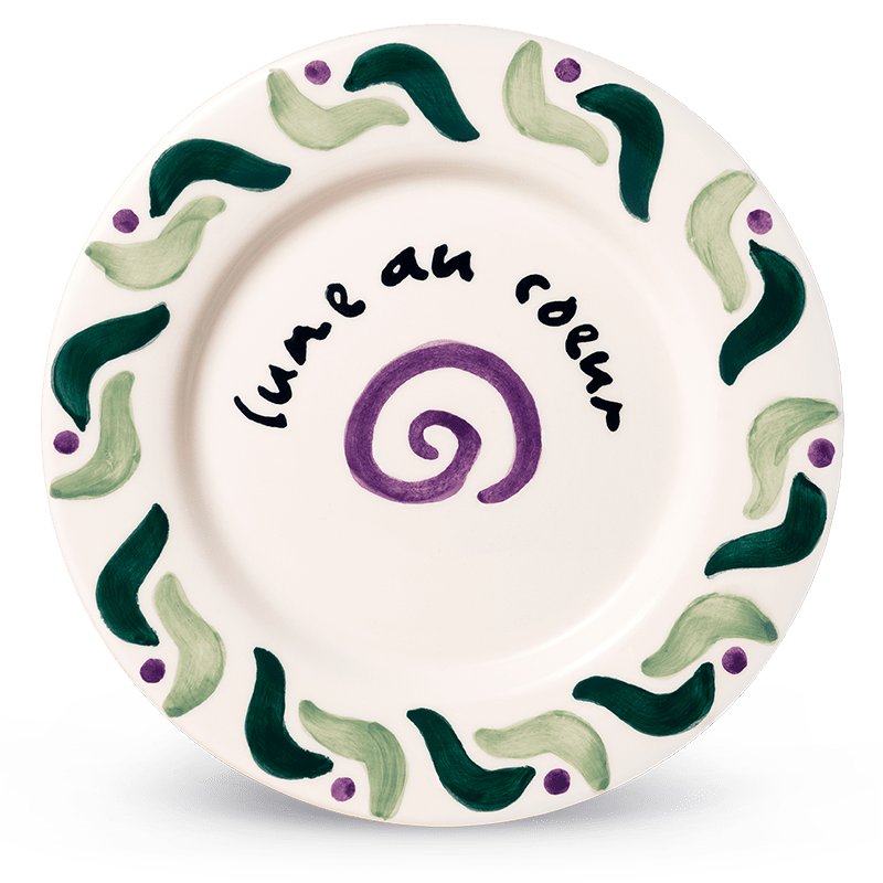 The Cala Secreta Plate by Octaevo features green and purple designs and a circling a purple spiral.