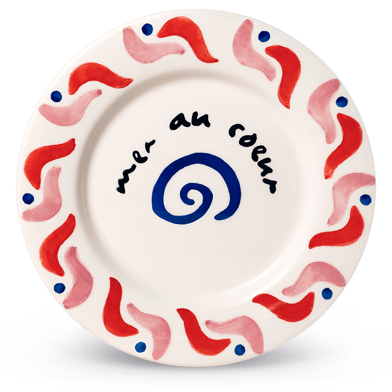 The Cala Secreta Plate by Octaevo features red waves, dots, a spiral, and black cursive at the center.