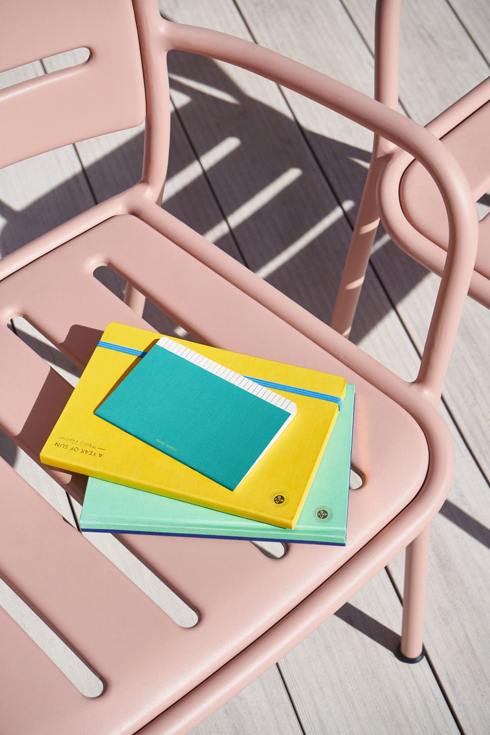 The mint OCTAEVO Classic Notes notebook sit on a pink chair, creating a luxe gift for relaxing days on the deck.