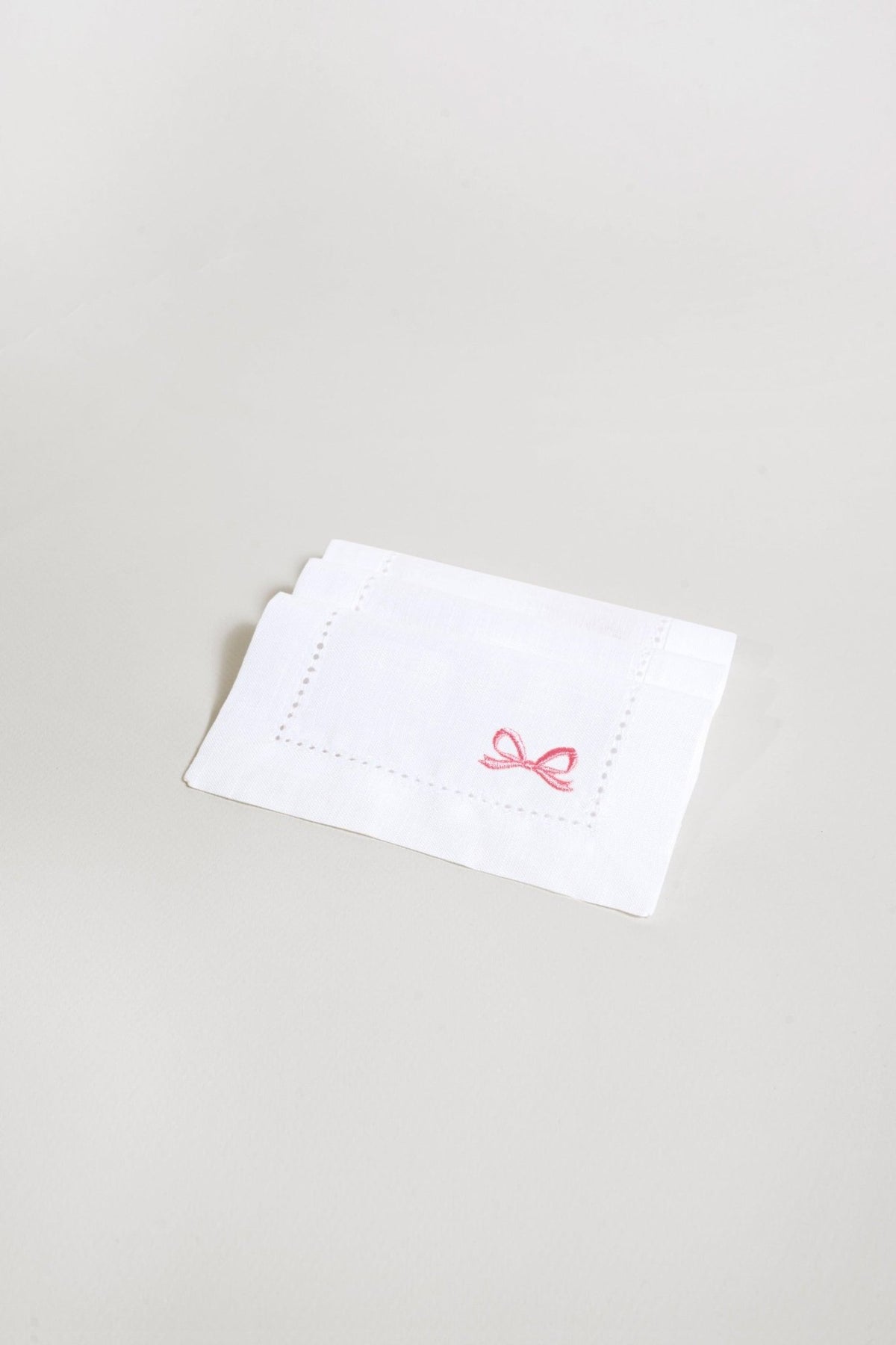 OCTAEVO Cocktail Napkin Bow (Set of 2): white linen, pink bow—stylish reusable cocktail napkins for any event.