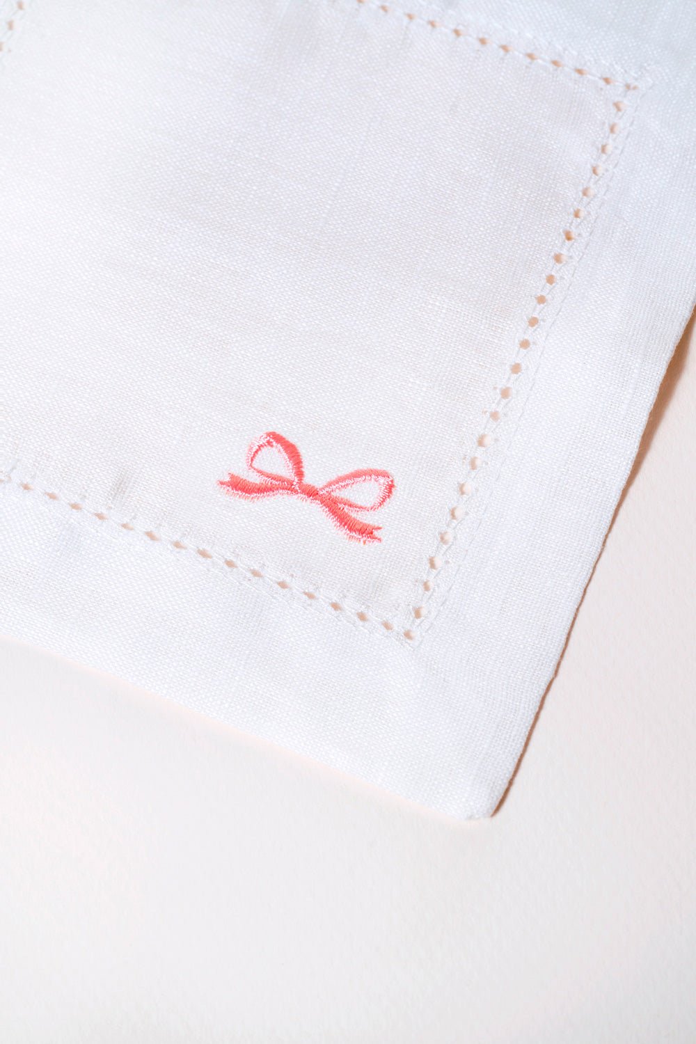 OCTAEVO's Cocktail Napkin Bow, Set of 2—white linen with pink bows—ideal reusable napkins for eco-friendly parties.