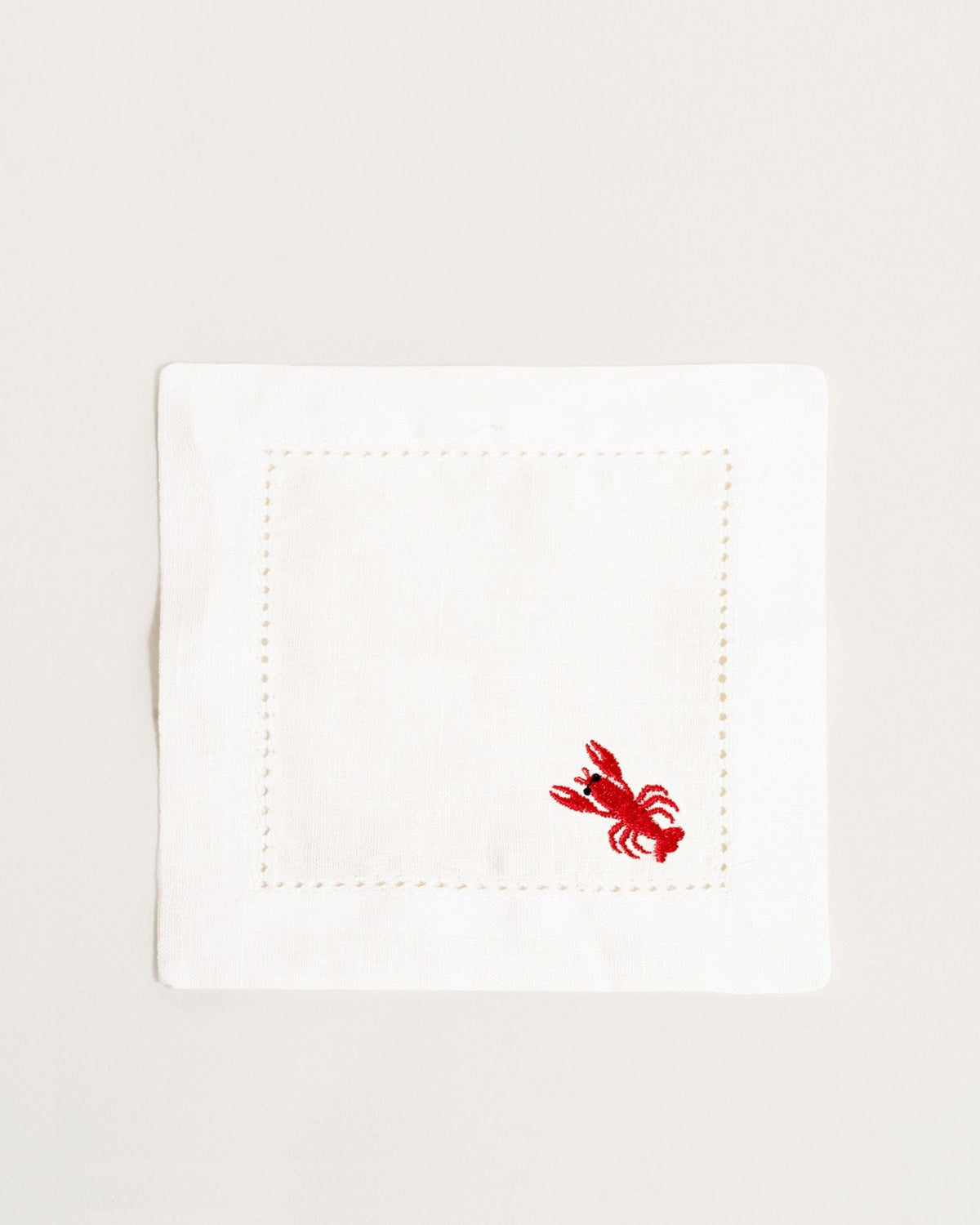 Set of 2 Octaevo Cocktail Napkins: white eco-friendly linen with small red embroidered lobster in the corner.