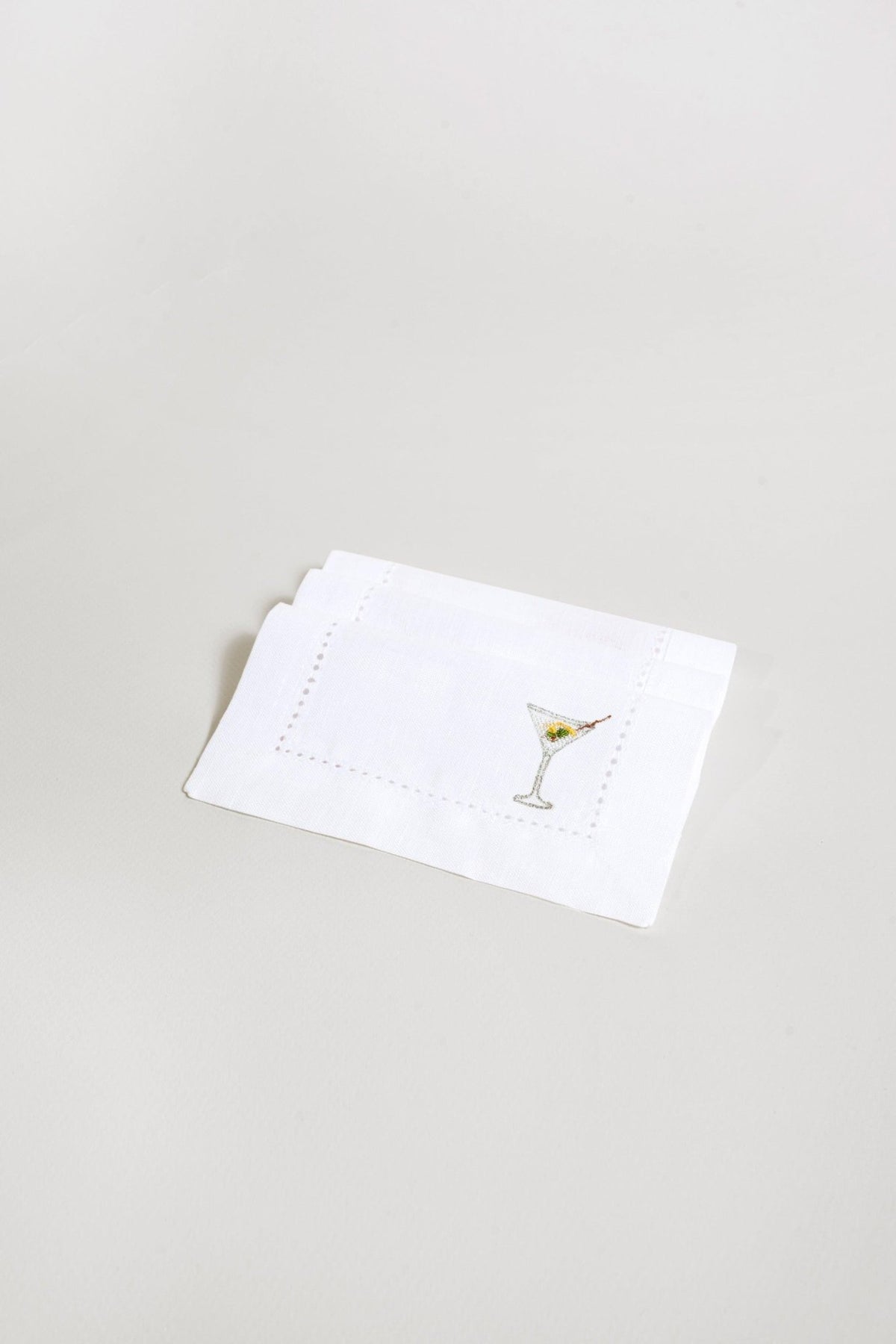 The Octaevo Cocktail Napkin Martini Set of 2 features white eco-friendly linen with embroidered martini glasses.