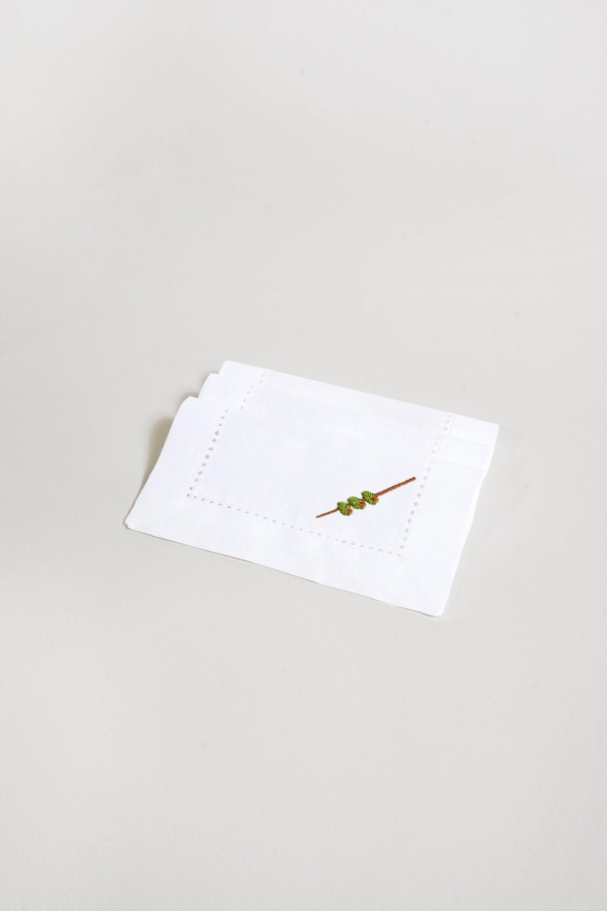 OCTAEVO's Cocktail Napkin Olive (Set of 2): white linen napkins with a skewer design, reusable and eco-friendly.