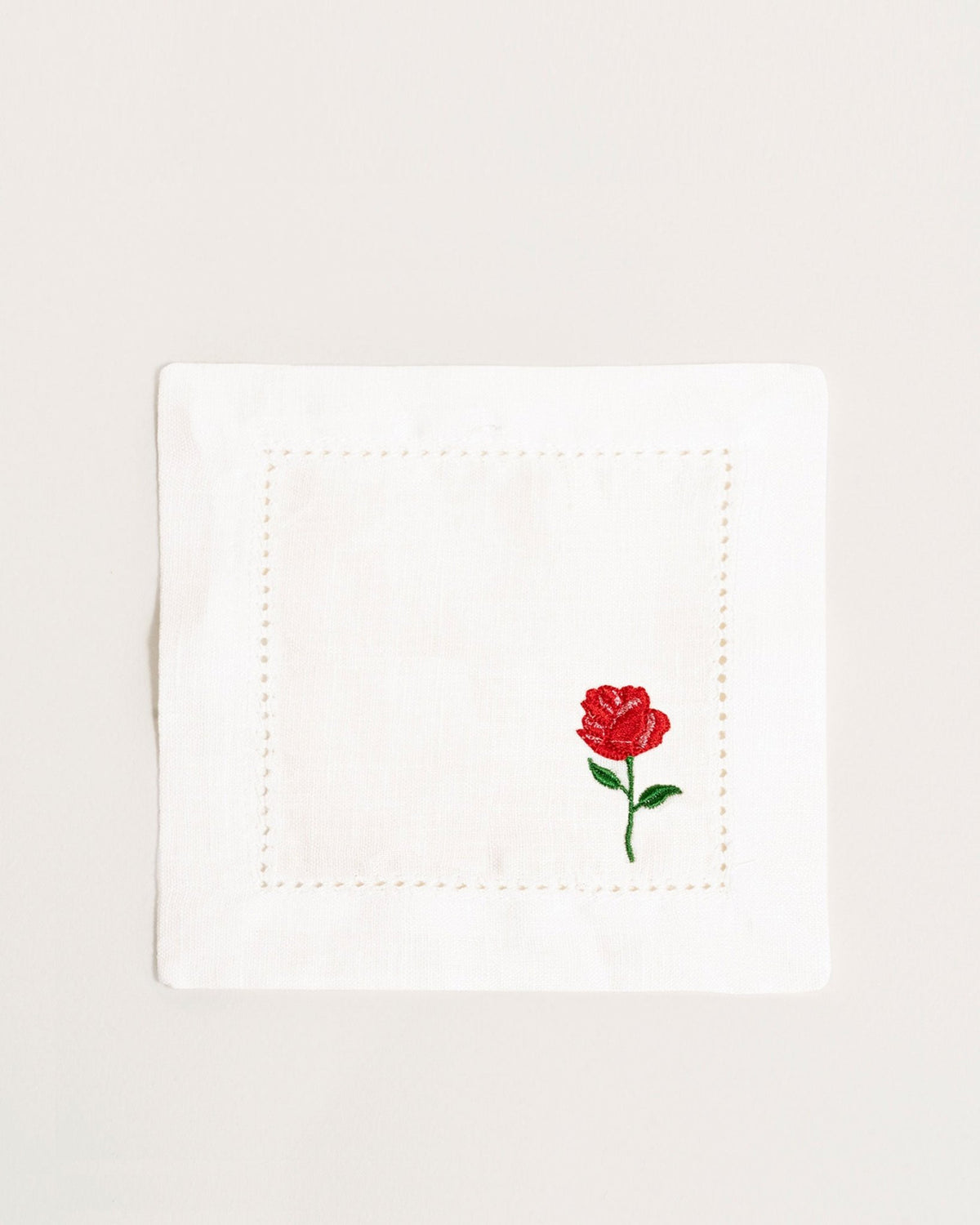 Octaevo Cocktail Napkin Rose, Set of 2—white linen with stitched border & red rose embroidery in one corner.