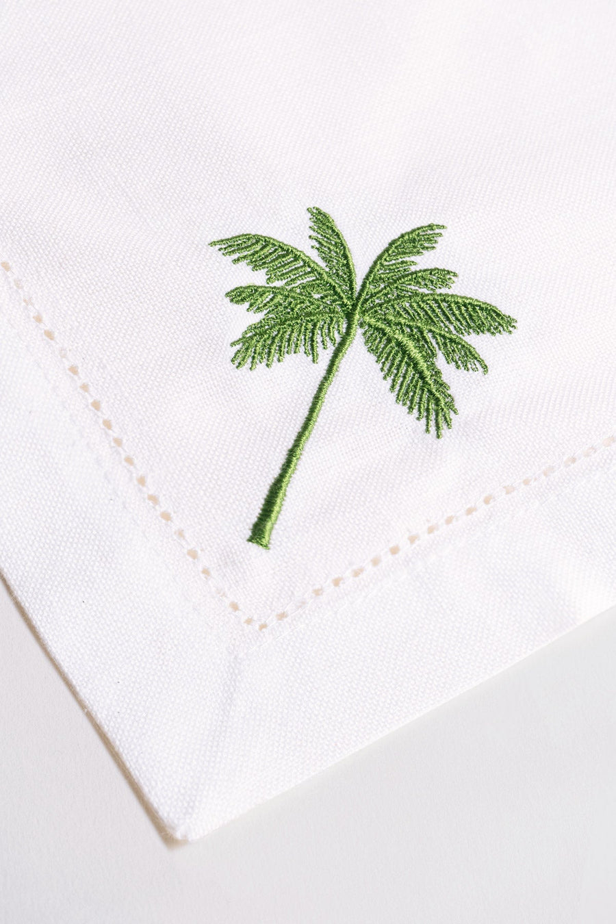 OCTAEVO Dinner Napkin Palm (Set of 2): White linen napkins with green palm embroidery near the corner.