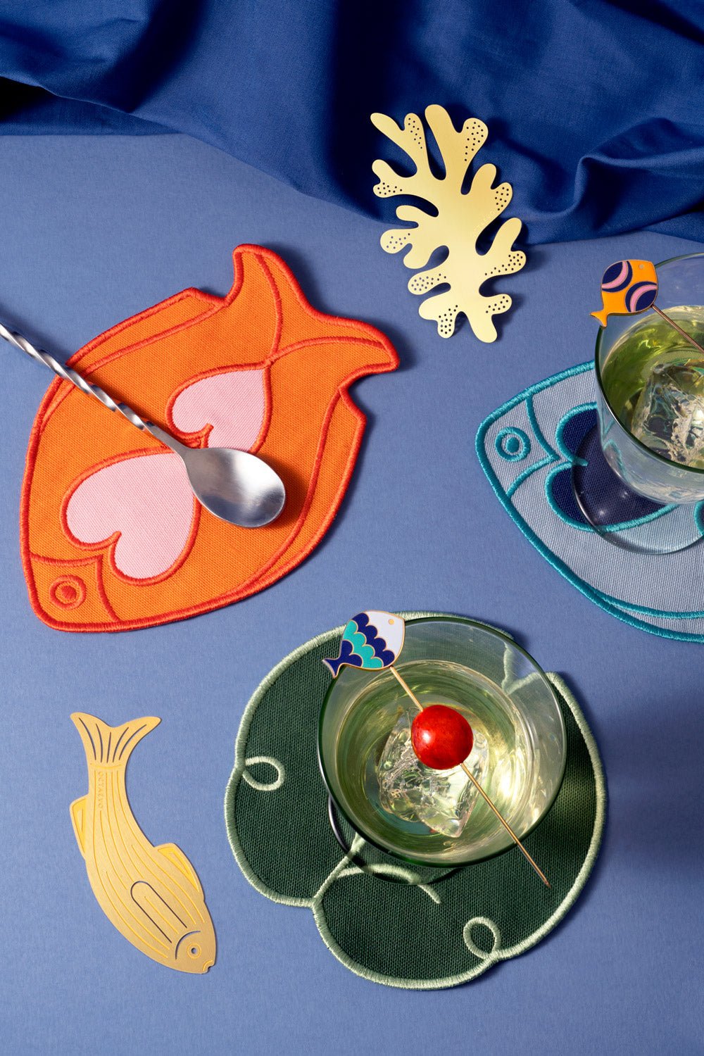 Colorful cocktails on Octaevo Fish Splash Coasters (Set of 4) in orange, featuring fish and coral bookmarks.