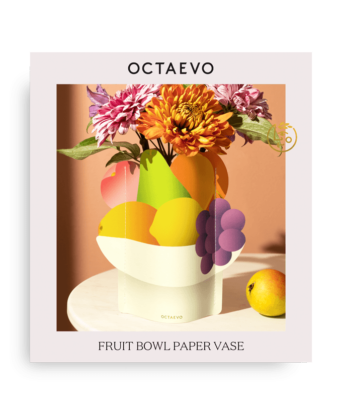 Bunte Obstschalen-Mini-Papiervase von Octaevo mit Obst und Blumen auf einem Tisch; der Text lautet OCTAEVO FRUIT BOWL MINI.