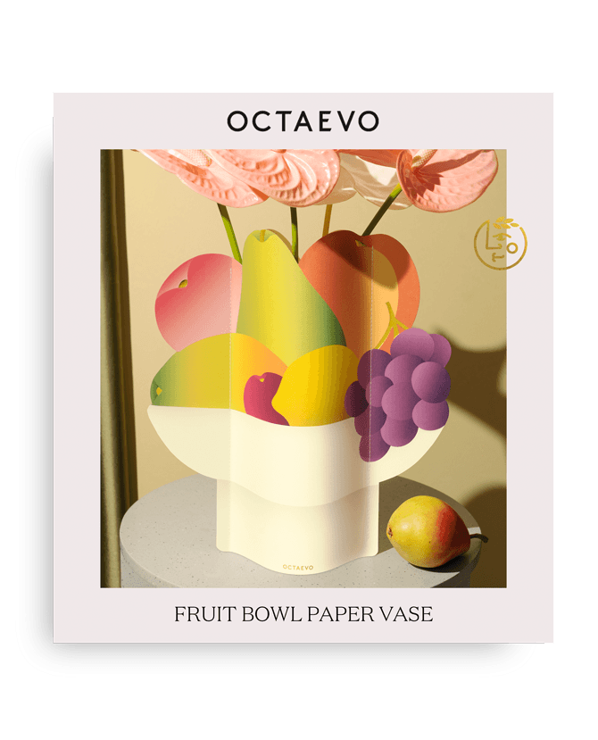 Die Octaevo Obstschalen-Papiervase hält Früchte als Mittelpunkt der Tafel, daneben eine Birne, präsentiert auf einem Tisch.