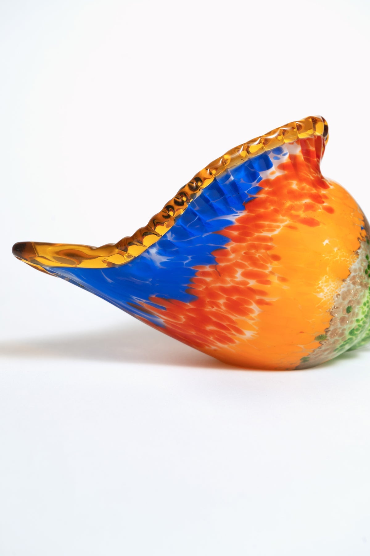 The Octaevo Glass Conch Shell Sculpture features a hand-blown, multicolored design with orange, blue, and yellow hues.