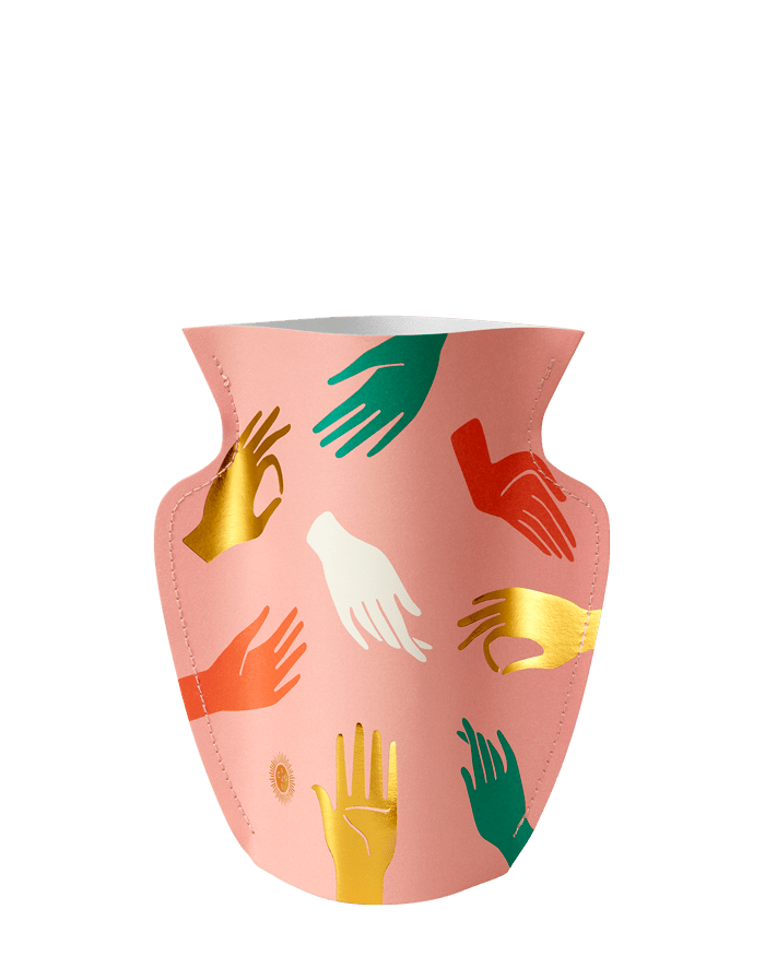 The Hamsa Mini Paper Vase by OCTAEVO is pink with colorful hand designs in green, gold, orange, and white.
