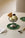 Pistachio ice cream in a metal cup on OCTAEVO Lily Leaf Coasters (Set of 4), with cherry, cookie, and spoon.