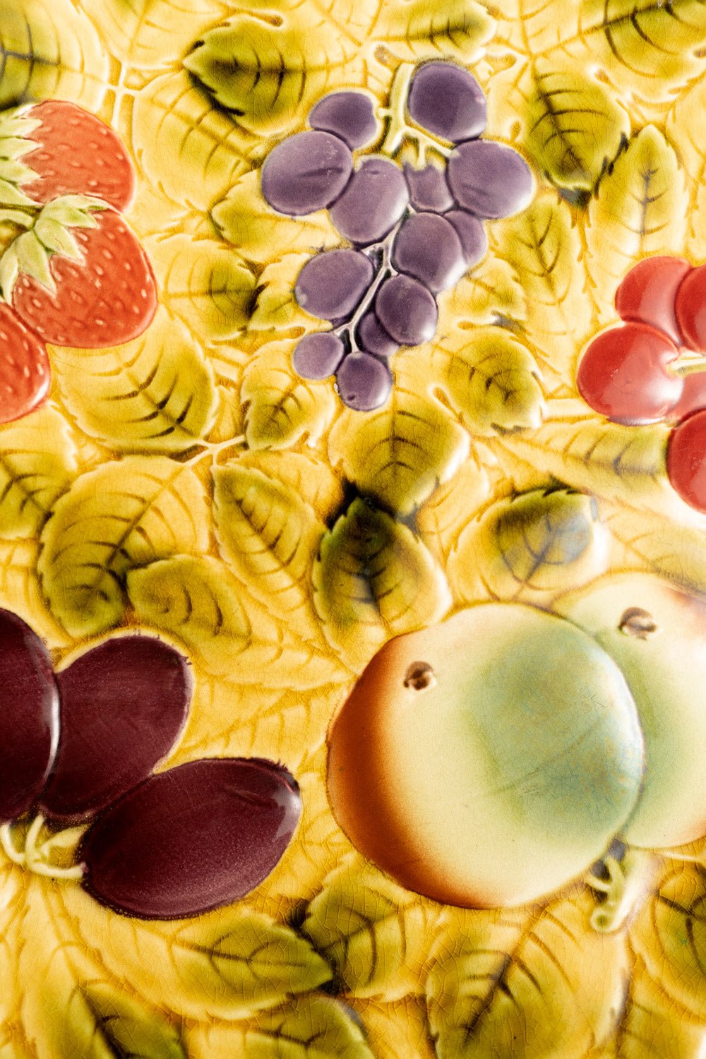 Close-up of OCTAEVO Majolica Serving Platter featuring colorful embossed fruit and leafy Art Nouveau patterns.