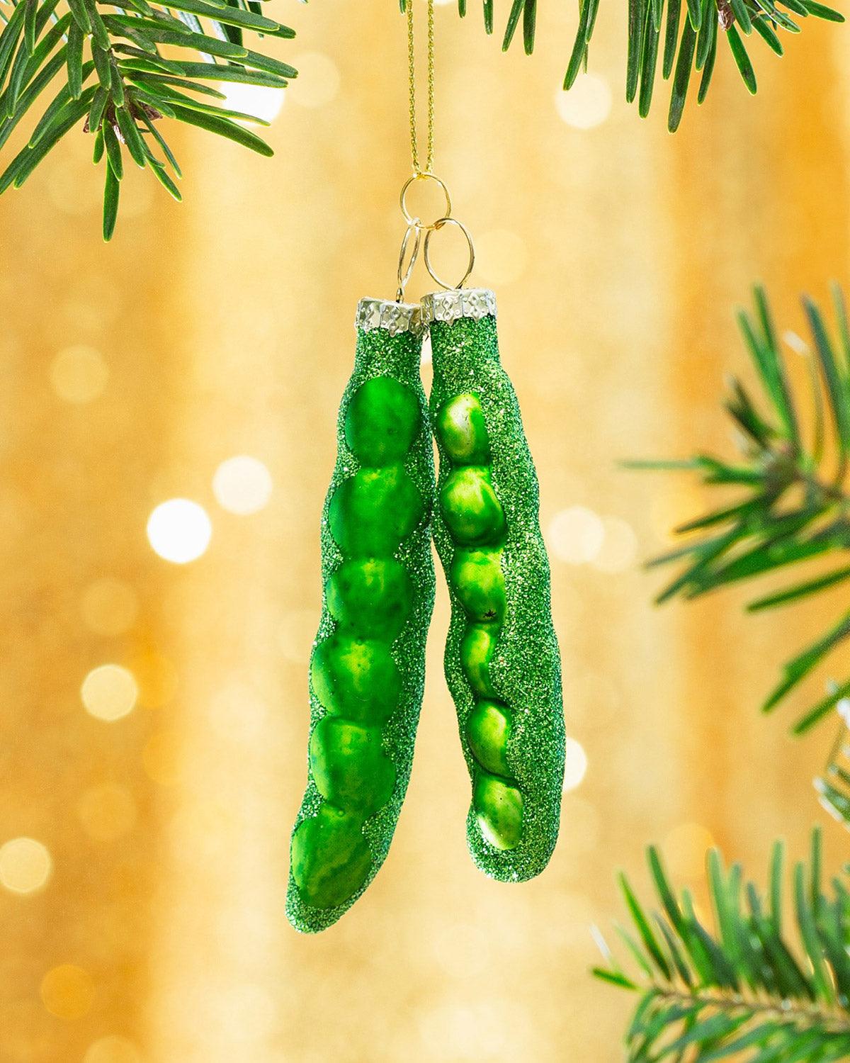 Octaevo Merry Greens Weihnachtskugeln (3er-Pack) hängen an einem Weihnachtsbaumzweig vor goldenem Bokeh-Hintergrund.