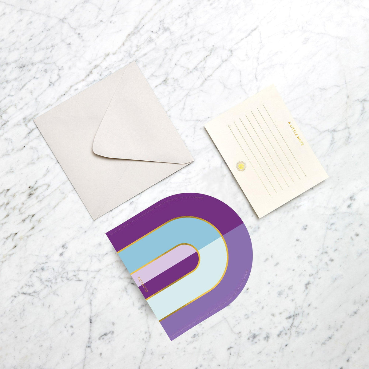 OCTAEVO's Riviera Arch Mini Paper Vase is a colorful, arch-shaped accent that makes a statement on white marble.