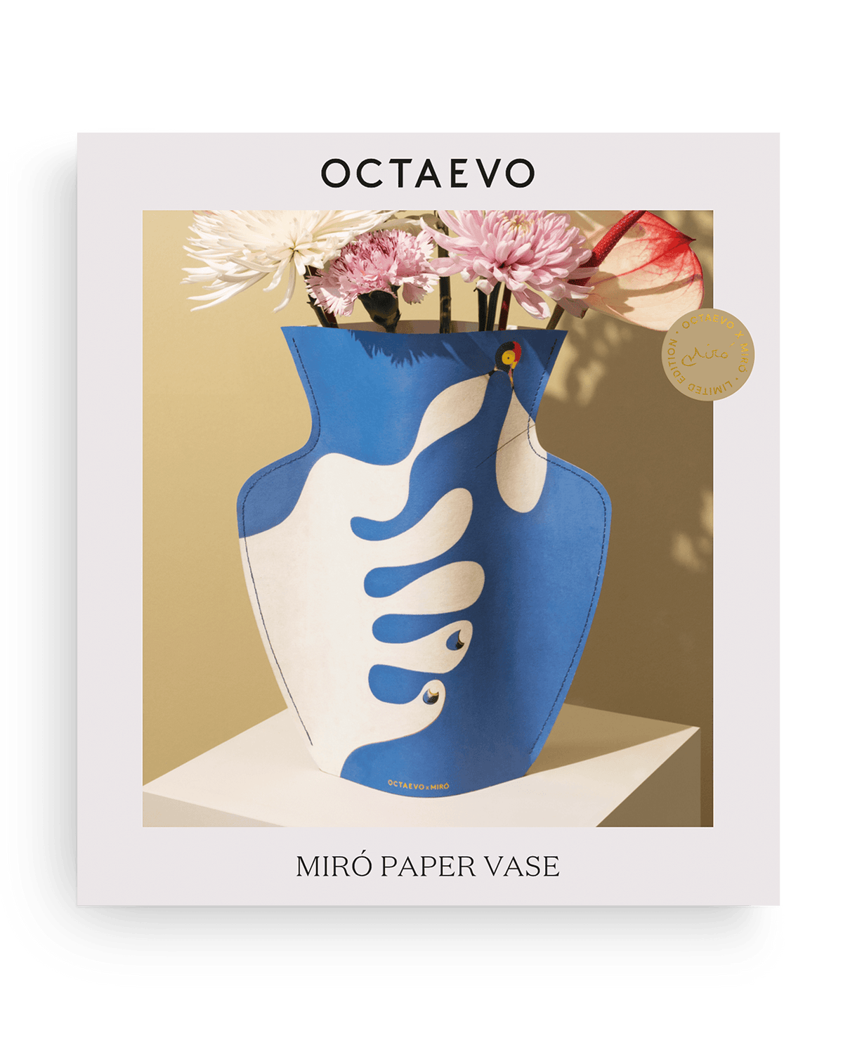 OCTAEVO Miró Paper Vase — Main à la poursuite d’un oiseau, blue/white, with flowers on a white background.