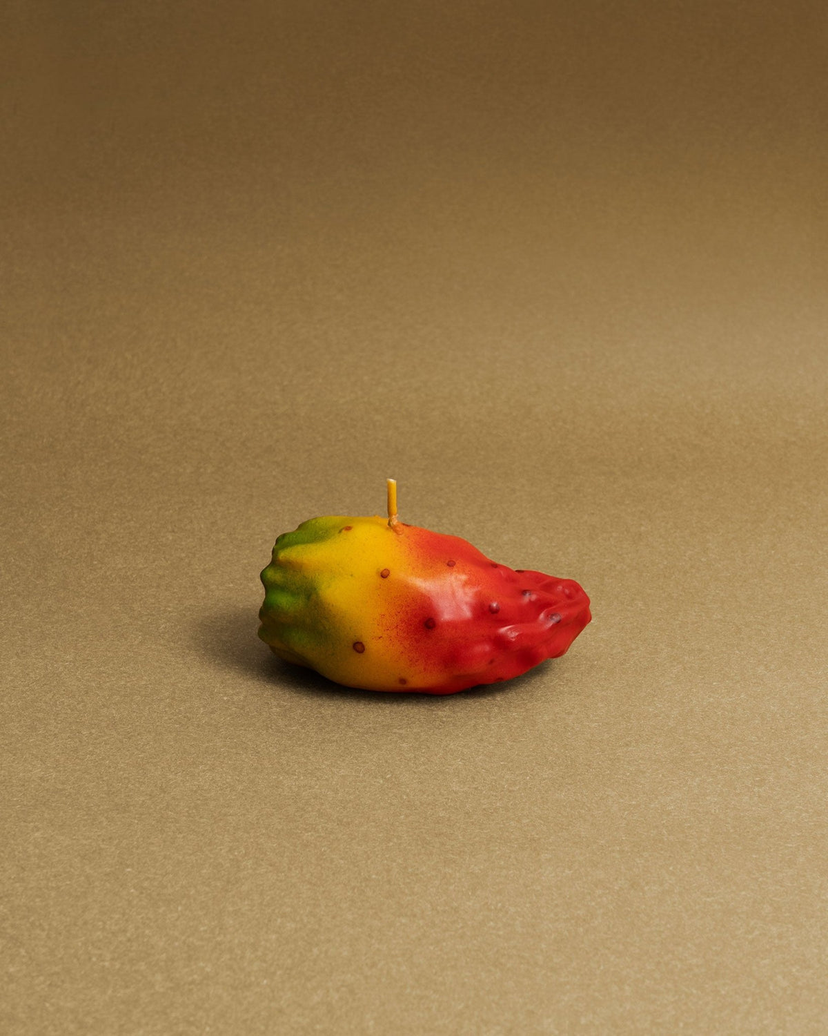 Octaevos Prickly Pear Candle adds vibrant charm to any tabletop, resembling the fruit in a playful, decorative form.