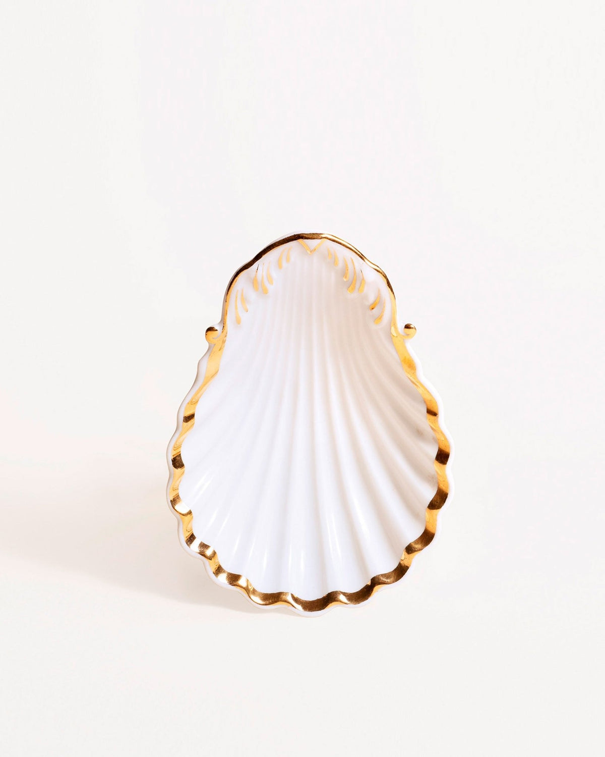 The Octaevo Shell Bowl is a white porcelain piece with gold edges, offering coastal elegance in a unique design.