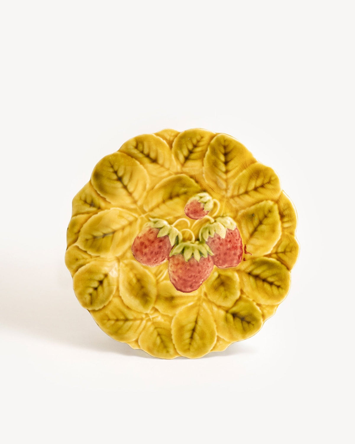 OCTAEVO Strawberry Majolica Plate, Art Nouveau style with embossed leaves and red strawberries, top view on white.