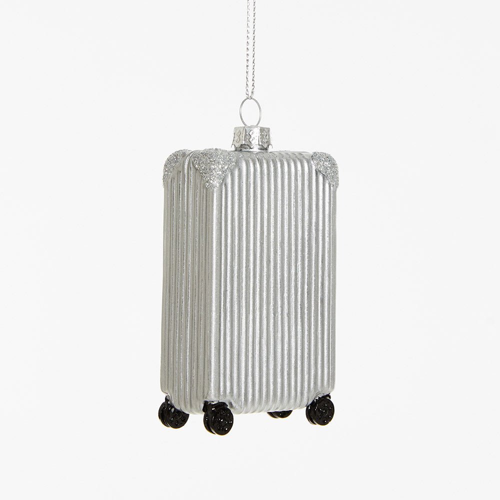 The OCTAEVO Suitcase Ornament with black wheels hangs from a silver string against a white background.