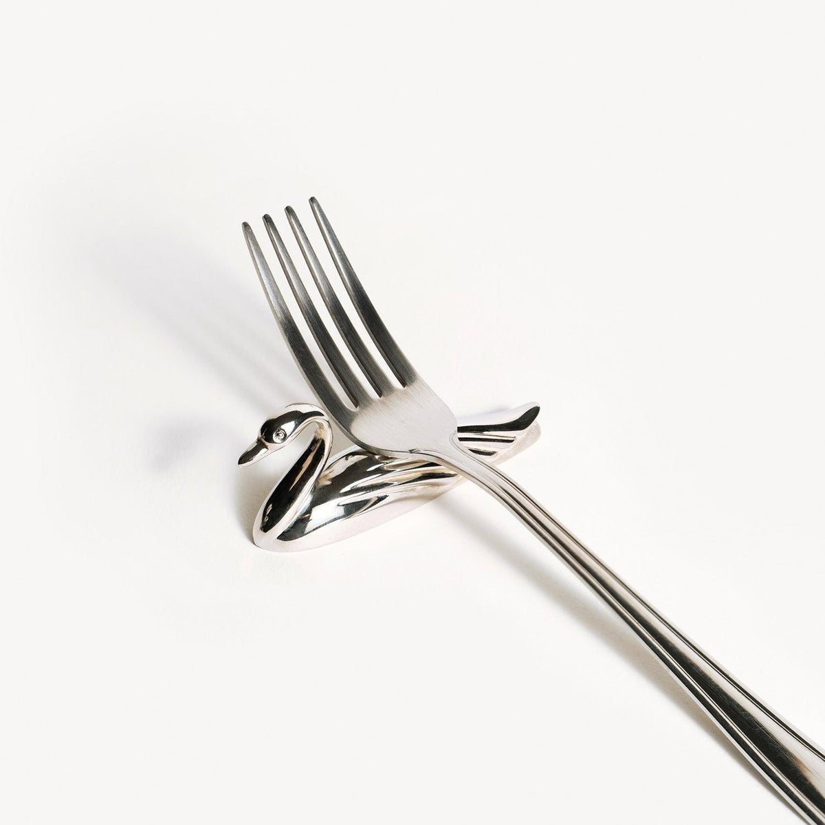 A silver fork rests on Octaevos Swan Knife Rests, Set of 2, against a plain white background.